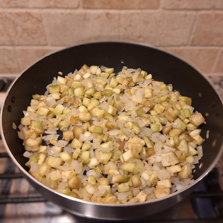 skillet with onion, garlic and eggplant cubes