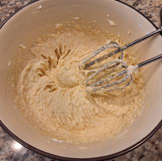In a large bowl, beat the eggs. Add the softened cream cheese, grated parmesan, garlic powder, and black pepper. Mix until smooth. Fold in the well-drained zucchini, cooked eggplant, onion, and almond or regular flour. Mix thoroughly.