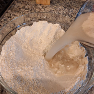 adding yeast and water mix to flour