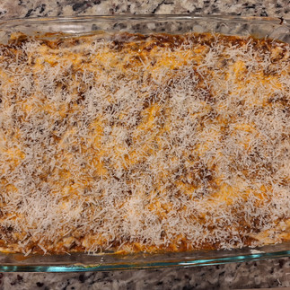 Preheat the oven to 375°F (190°C). In a large baking dish, spread a thin layer of meat sauce on the bottom. Place a layer of lasagna noodles on top, followed by a layer of the ricotta mixture, then meat sauce, and finally a drizzle of béchamel. Repeat layers, finishing with béchamel on top. Sprinkle Parmigiano-Reggiano lightly on top for a balanced finish.