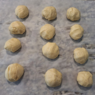 12 dough balls on parchment paper