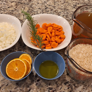 2 cups rice 1 onion, diced 2 carrots, sliced 2 tbsp olive oil (for sautéing) 4 cups chicken broth (or water) 1 orange, sliced (for topping) 1 rosemary branch (whole, for flavoring) Salt and pepper to taste Fresh parsley or cilantro (optional, for garnish)