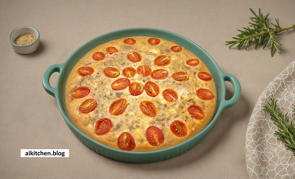 Baked dish with cherry tomatoes in a teal dish on a beige surface. Rosemary and a small bowl nearby. Text: aikitchen.blog. Cozy mood.