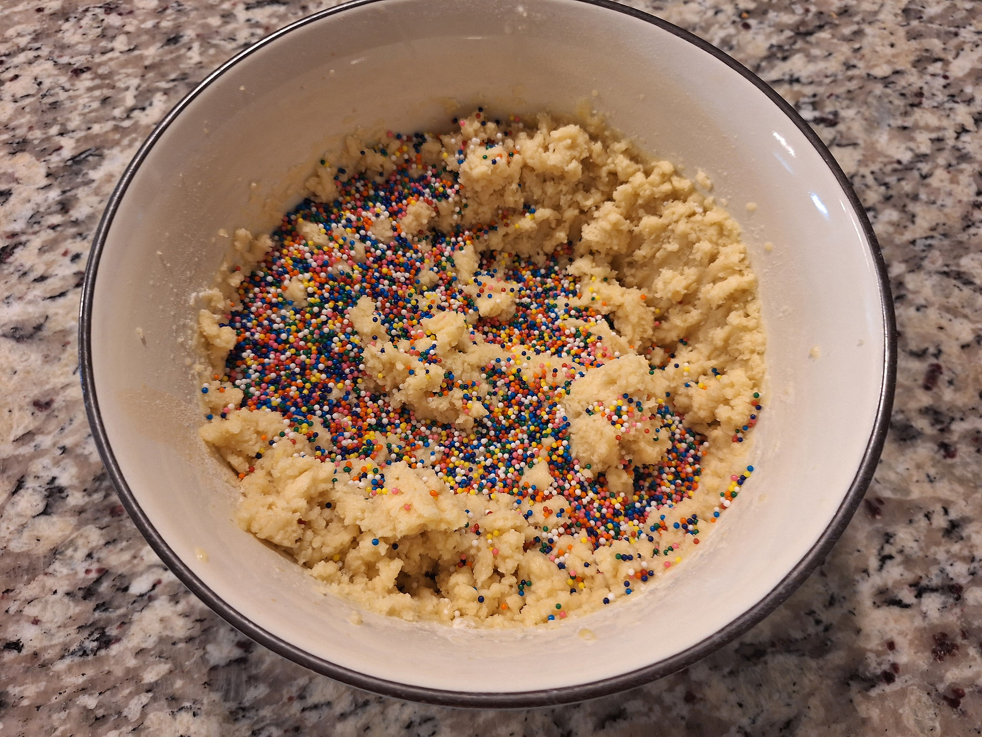 In a large bowl, cream together butter, oil, powdered sugar, and granulated sugar until light and fluffy.  Mix in the egg and vanilla until smooth.  In a separate bowl, whisk together flour, salt, and baking powder.  Gradually mix dry ingredients into wet ingredients until a soft dough forms.  Fold in sprinkles gently to prevent color bleeding.  If the dough is too soft, chill for 30 minutes.