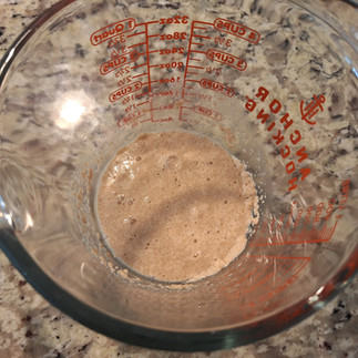 water sugar and yeast in a measuring cup, foamy