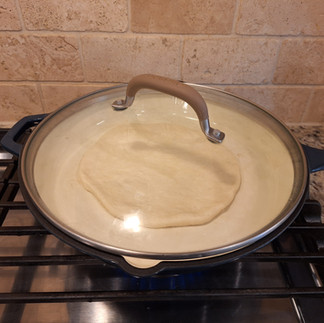 Heat a dry enameled cast iron skillet over medium-high. When hot, lay in one dough circle. Optional: Cover loosely with a lid for the first 30–60 seconds to trap steam and help puff. Cook 1–2 minutes per side until it bubbles and develops golden spots.