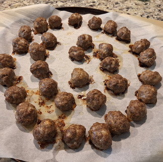 baaed meatballs arranged on a pan