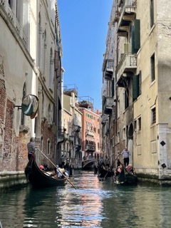 Venetian canal with sky reflecting in water