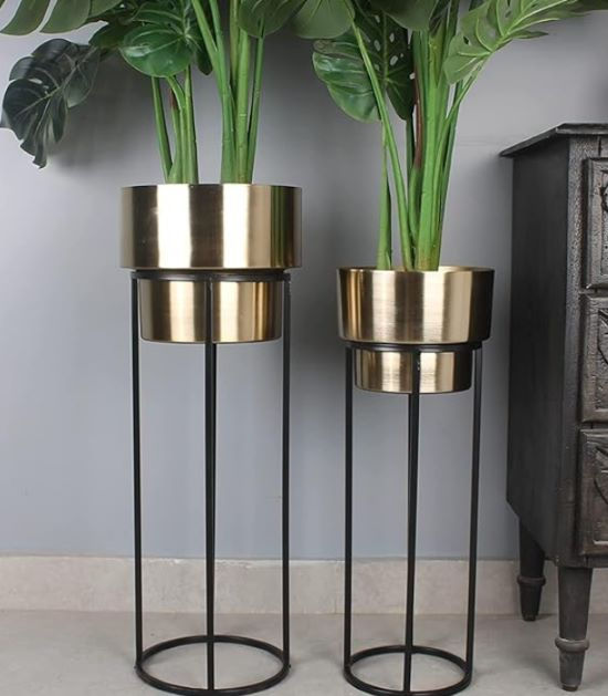 Set of two modern, tall gold metal planters on sleek black metal stands