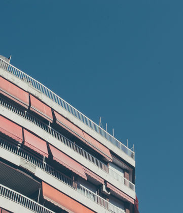 Apartment building with red awnings against a clear blue sky