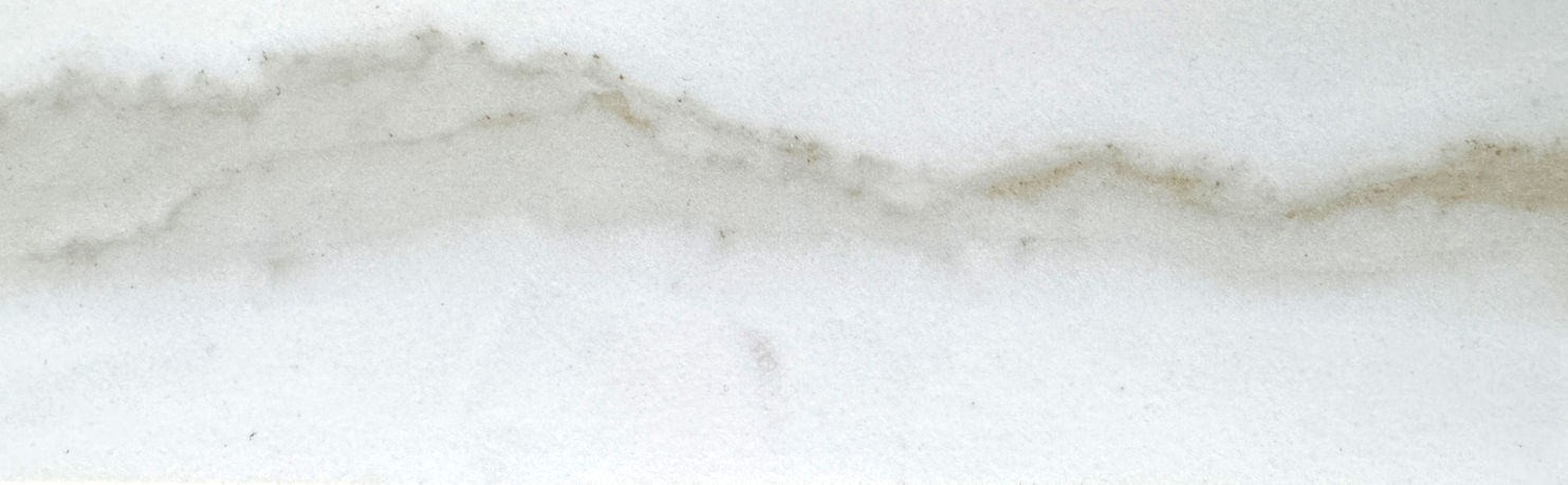 Sinterizado Neolight Estatuario Silk con fondo blanco y vetas grises, ideal para encimeras modernas y elegantes.