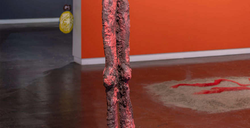 galley with orange walls and red sculpture with legs in middle of space 