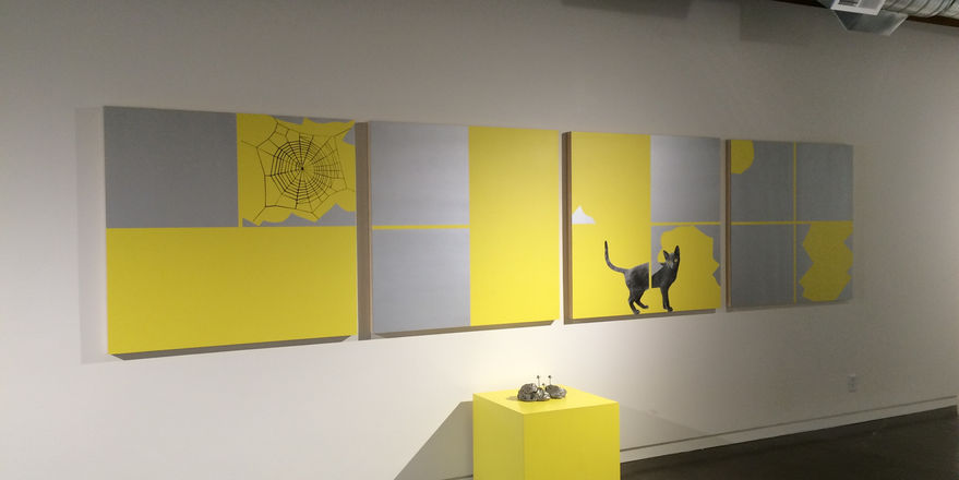 Abstract yellow paintings mounted on wall and yellow box on floor