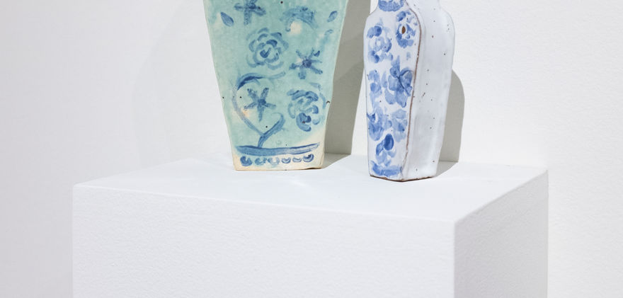 Close up of mint green vase and smaller white vase.