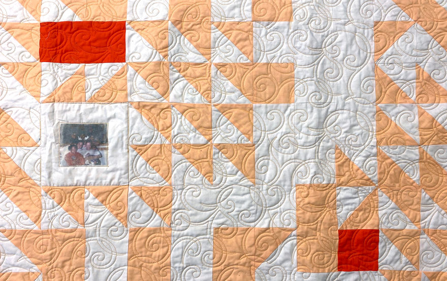 Close up image of In a solitary life there are rare moments when another soul dips near yours as stars brush the earth, quilt with stitch floral patterns, squares and triangles with a photo transfer.