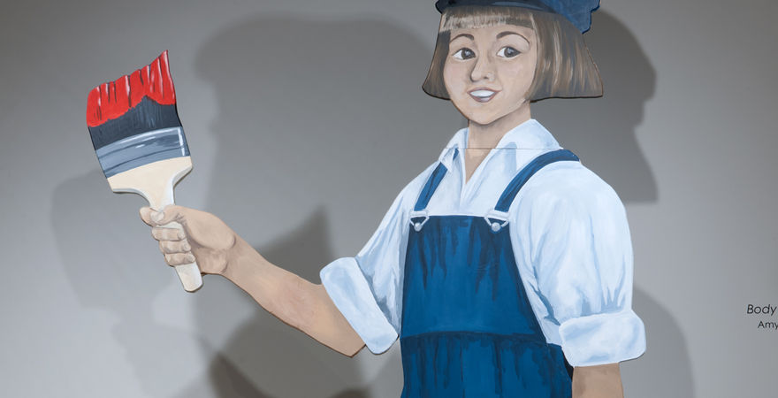 painting on wood of small boy with paintbrush and overalls