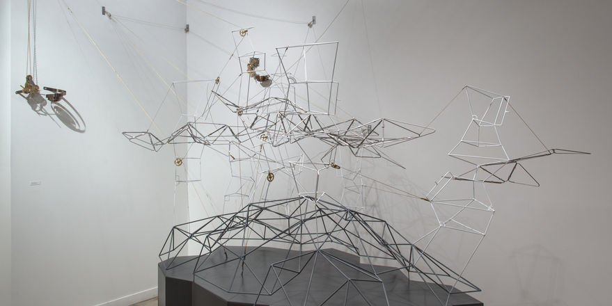 Metal abstract sculptures on dark grey mounts in gallery