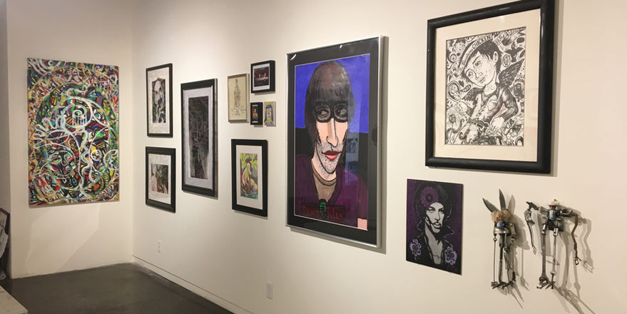 Gallery with various sizes of two dimensional works on paper and canvas with two small sculptures in corner 