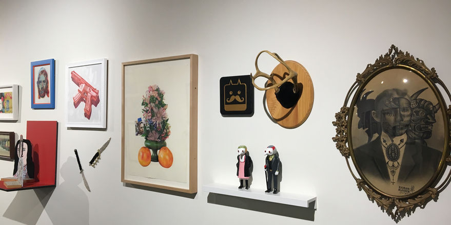 Gallery with pieces of art of various sizes and mediums and a white pedestal with two small sculptures of mice and a red pedestal with a small sculptural piece 