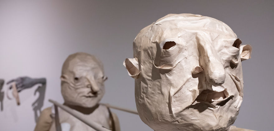 Close up of paper figures faces.