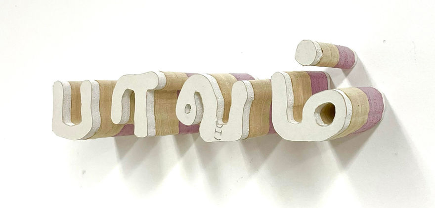 White lettered sculpture on wall.