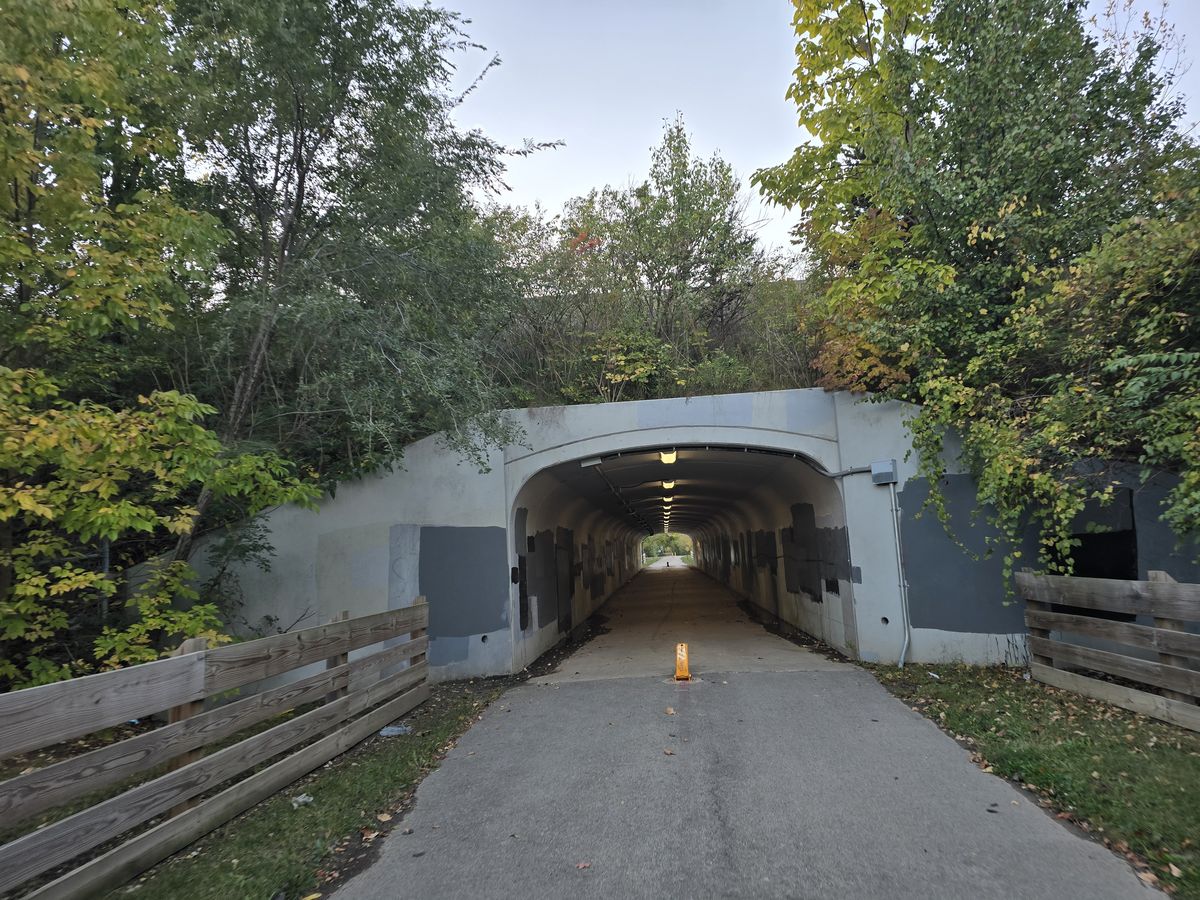 The trail leads into a tunnel beneath the road.