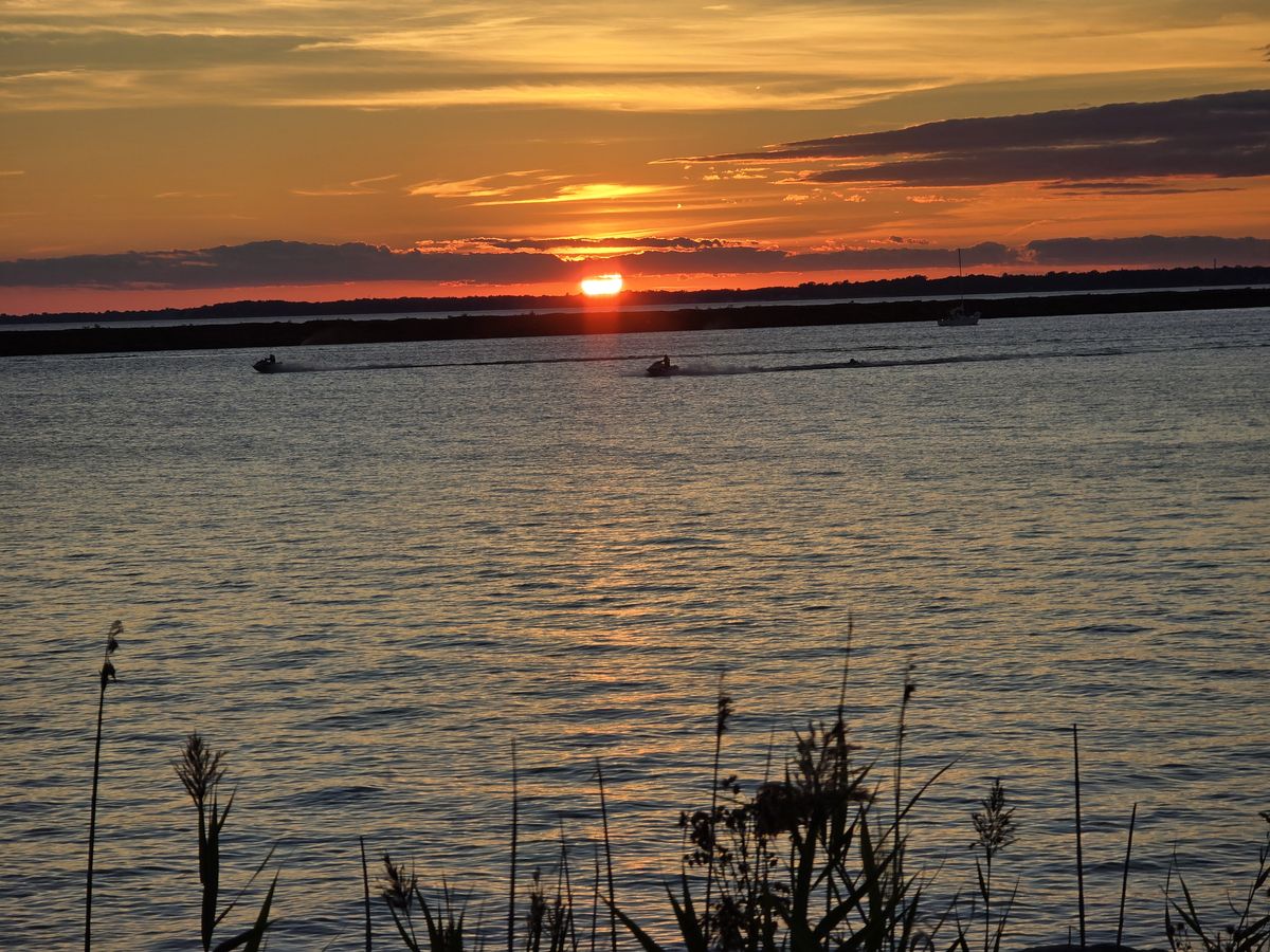 The sunset kept changing colors over the water.