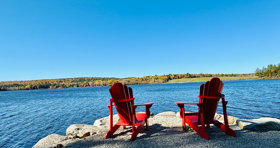 Two red chairs sitting on a point on Mockingee Lake