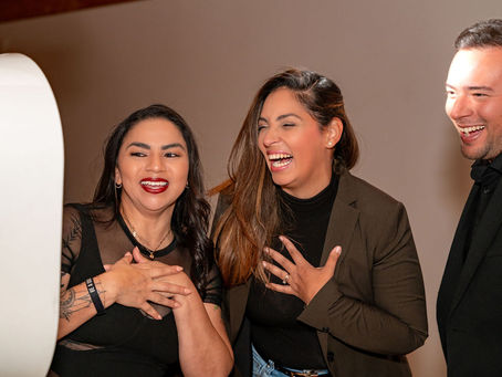 Three people smiling and laughing at their picture