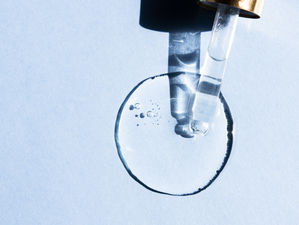 transparent-liquid-drop-peptide-hyaluronic-acid-with-glass-pipette-blue-background-min.jpg