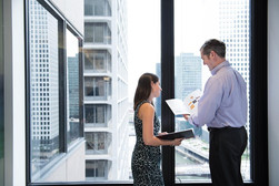 young professionals meeting in office with city window background