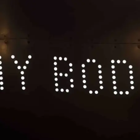 The word ‘body’ displayed against a dark background, symbolizing introspection, body image struggles, and the silent impact of eating disorders.