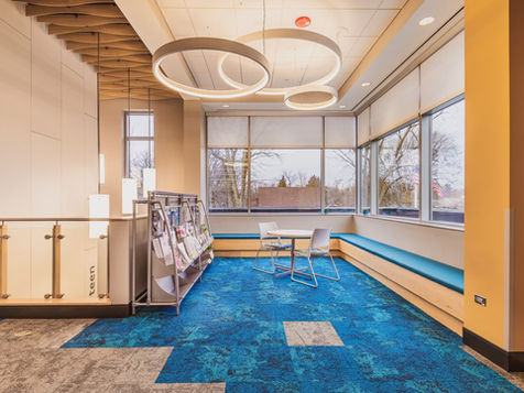 Modern reading area with blue carpet and large windows