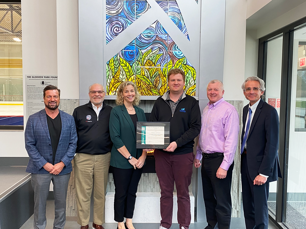 Six people standing together, one holding a framed award