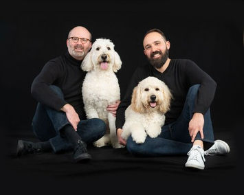 Gay couple with white poodles elegant family portrait