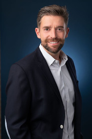 Casual CEO portrait headshot on blue background