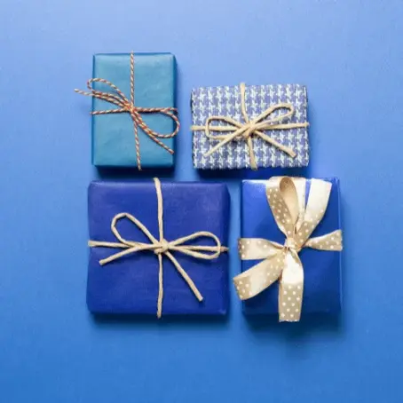 Blue-themed holiday image featuring four patterned gift boxes on a blue background, visually representing the emotional weight and loneliness of the holiday blues.