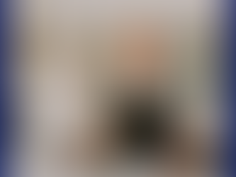 Justine Campbell John next to a white 'It's Not Just Cake' cake she made