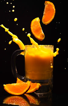 Oranges falling in a glass of orange juice, creating a splash. Taken in the Northern Arizona University photography studio in Flagstaff, Arizona