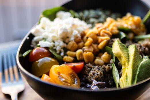 A close up photo of a colorful salad with tomatoes, corn, and avocado. Taken at Urban Pine Eatery in Flagstaff, Arizona.