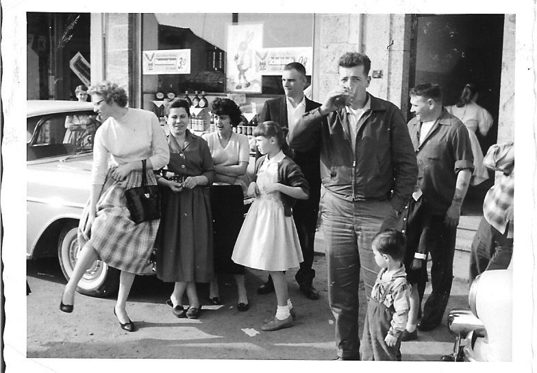 A family group on the sidewalk outside a store