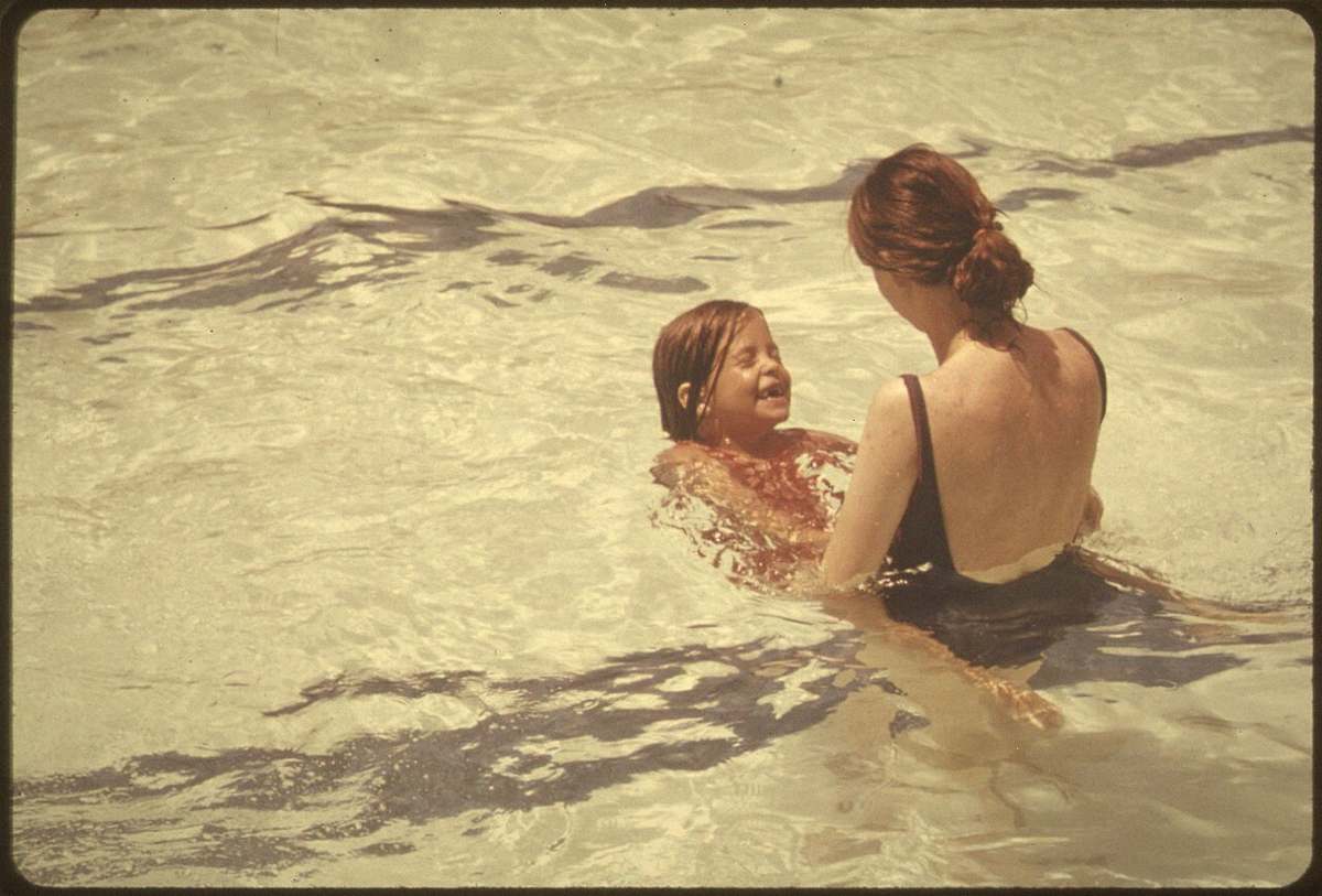A mother and daughter in a public swimming pool, 1970s