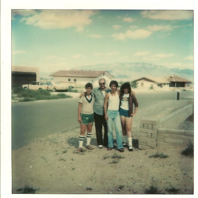 A family outside a new house in the desert