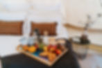 Bed in a glamping bell tent with a breakfast tray on top