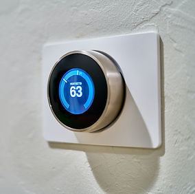 gray Nest thermostat displaying at 63_ed