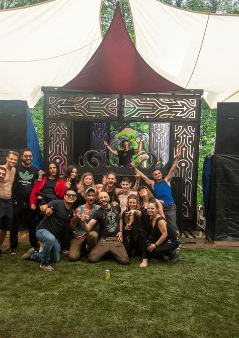 Groove & Bass festival crew posing together in front of forest stage during event setup