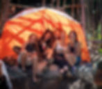 Group of friends relaxing and smiling inside camping tent at Groove & Bass festival