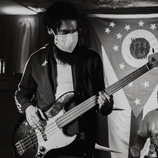 Black and white photo of bassist and drummer wearing face masks before livestream concert