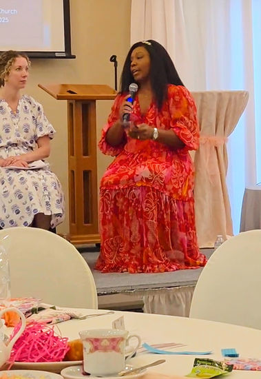 Destiny sitting as moderator on stage with a panel of women