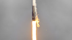 A rocket blasting off with the flame coming from the booster